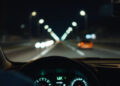 Armaturenbrett eines Autos bei Nacht aus Fahrerperspektive
