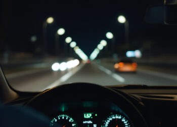 Armaturenbrett eines Autos bei Nacht aus Fahrerperspektive