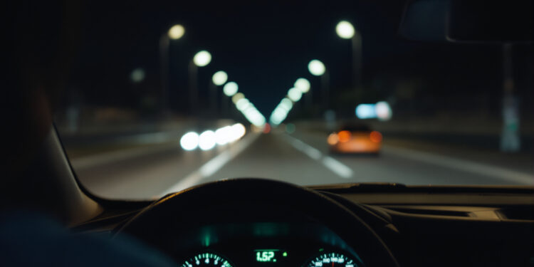 Armaturenbrett eines Autos bei Nacht aus Fahrerperspektive