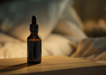 Cannabisöl-Tropfflasche auf Nachttisch in warmem Abendlicht