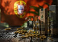 Vape-Cartridges und Hanfprodukte auf dunklem Holz mit portugiesischer Flagge