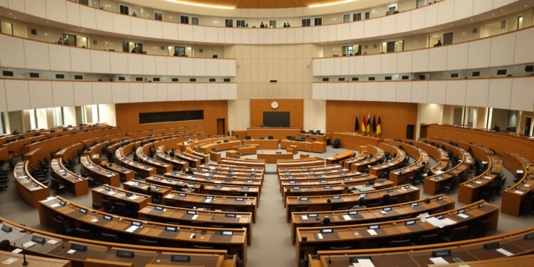 Bundesrat-Plenarsaal mit leeren Delegiertenplätzen in Holz und Creme