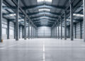 Leere Industriehalle mit Betonboden und Stahlträgern