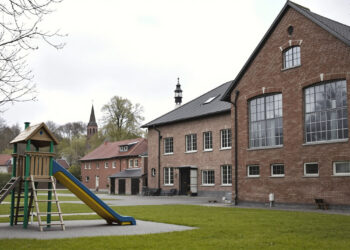 Spielplatz vor industrieller Halle in sächsischem Dorf