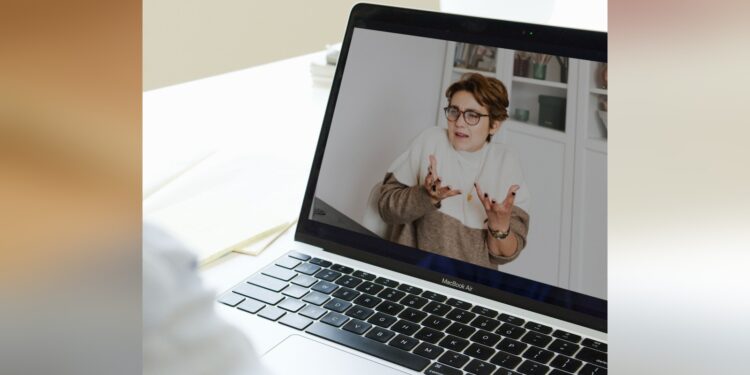 Patientin im Videogespraech mit einer Aerztin am Laptop